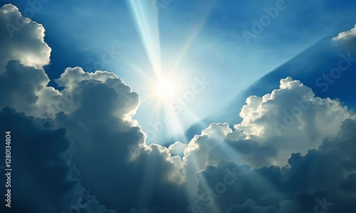 Sun rays shining through dramatic clouds in blue sky. 

