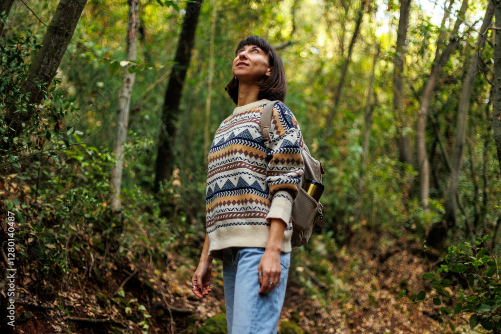 woman in a sweater and a backpack on her back travels. on a hike in the mountains. Young happy tourist woman relaxing in nature woman in a sweater and a backpack on her back travels. on a hike in the mountains. Young happy tourist woman relaxing in nature