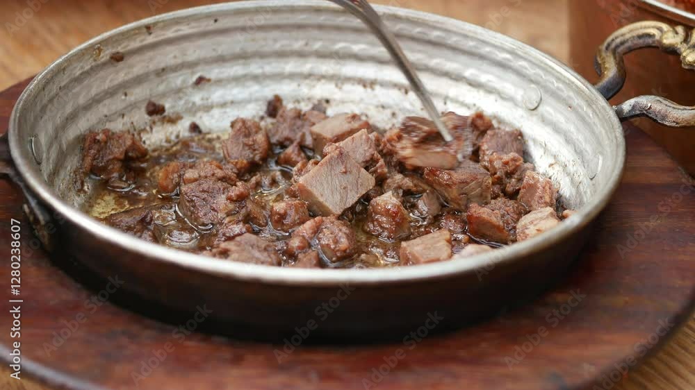 Cooked Meat in a Traditional Metal Bowl with Fork on Wooden Table Cooked Meat in a Traditional Metal Bowl with Fork on Wooden Table