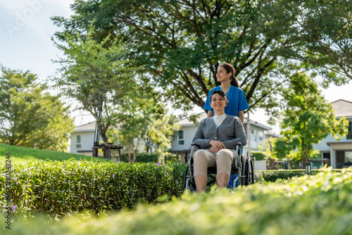 Bilde på lerret caregiver pushing wheelchair in park, enjoying sunny day