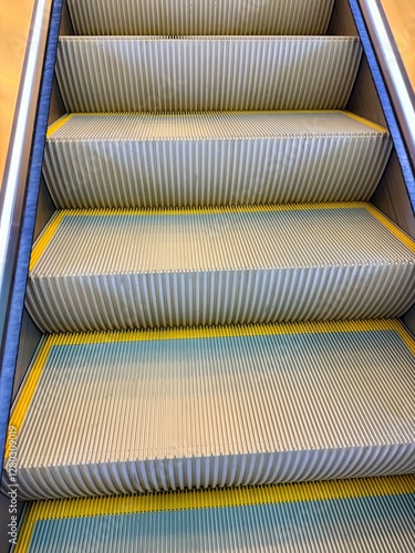 Fotografija Close-up view of an escalator with metallic grooved steps and yellow demarcation lines