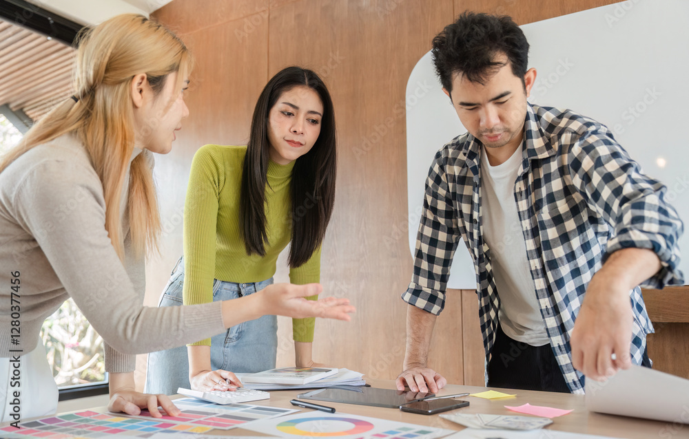 Diverse team collaborating on design project in modern office workspace. Diverse team collaborating on design project in modern office workspace.