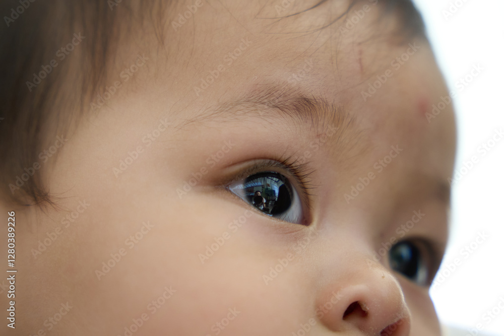 there is a baby that is looking at something with a toothbrush in his mouth there is a baby that is looking at something with a toothbrush in his mouth