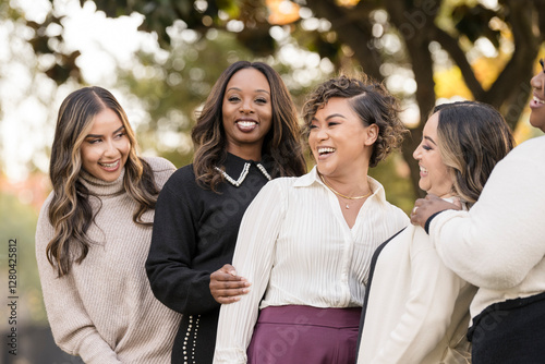 A joyful group of friends sharing laughter in an autumn park setting photo