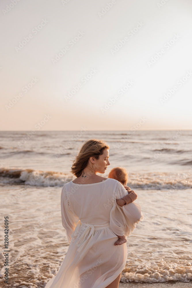 Woman in a flowing white dress standing in ocean waves at sunset Woman in a flowing white dress standing in ocean waves at sunset
