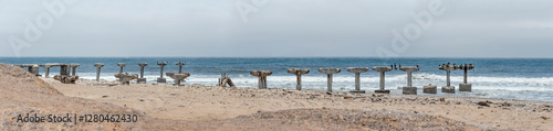 Obraz na płótnie Cormorans on run-down pier at Ocean shore, Toscanini old mining site, Skeleton coast, Namibia w salonie