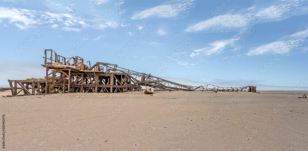 collapsed derrick of Drill Rig relic on desert sand, Old oil Rig site, Skeleton coast, Namibia