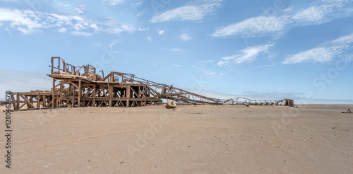 Obraz na płótnie collapsed derrick of Drill Rig relic on desert sand, Old oil Rig site, Skeleton coast, Namibia w salonie