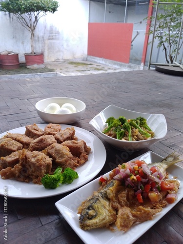 spicy fried fish, fried tofu and boiled egg on wooden table