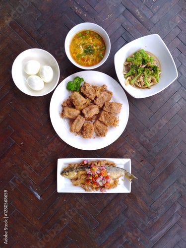 spicy fried fish, fried tofu and boiled egg on wooden table