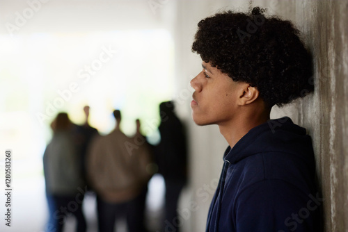 Contemplative man with Afro hairstyle leaning on wall