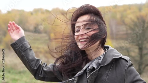 Autumn landscape with woman has windy hair. Stylish woman sing in autumn landscape outdoor. Fall nature landscape and girl. Central park in New York. Girl in fall trench. Alone in the vast desert