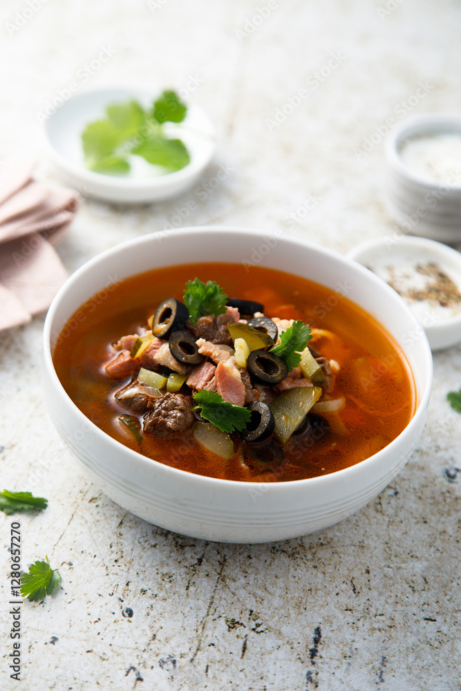 Meat soup with gherkins and olives