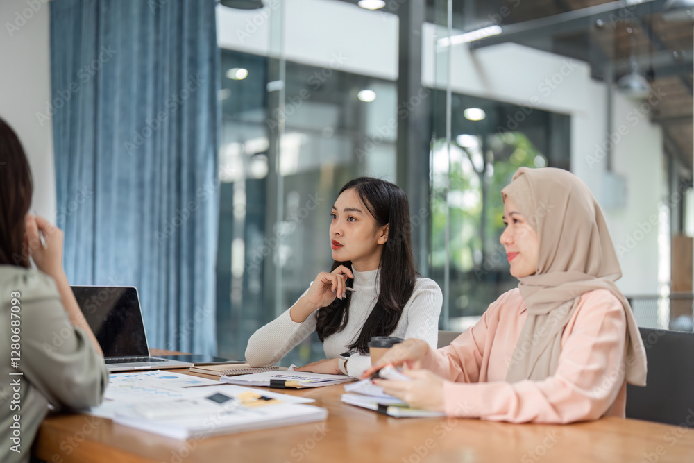 Women discussing project strategies in a contemporary office setting. Women discussing project strategies in a contemporary office setting.