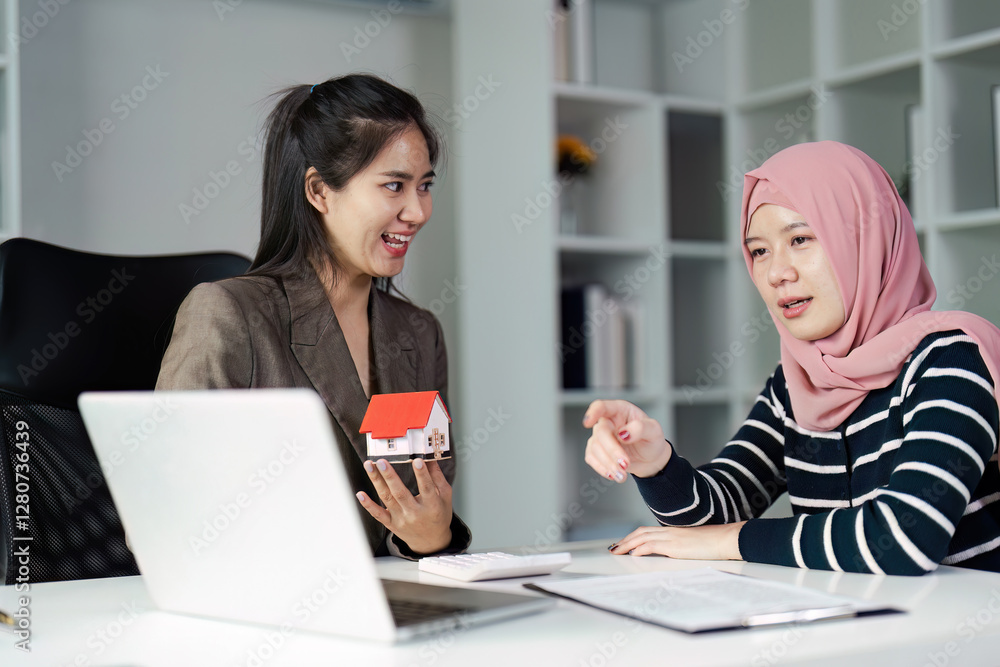 Real estate agent and client discussing property options with a model house in a stylish office environment. Real estate agent and client discussing property options with a model house in a stylish office environment.