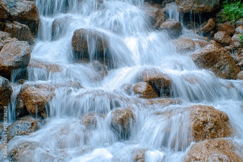 A small waterfall flows over rocky terrain