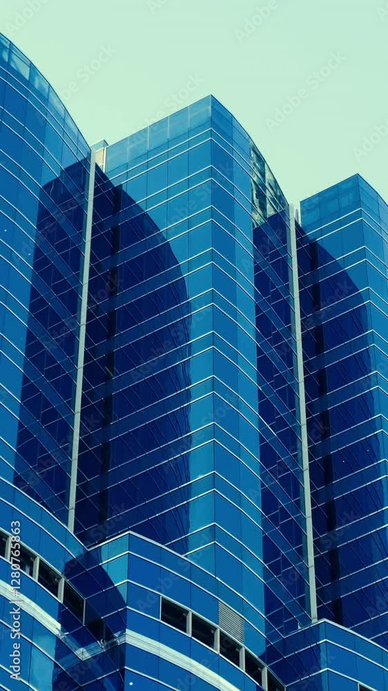 Modern walls are made of glass and steel with reflections of blue sky. Modern walls are made of glass and steel with reflections of blue sky.