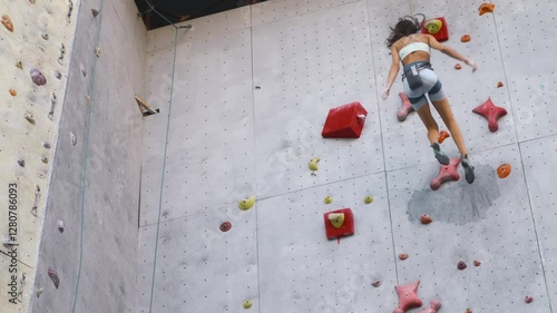 Wallpaper Mural woman climber on artificial climbing wall in city. active female climbing grey rock wall with bright red holds. Sport weekend action in adventure park. Active lifestyle concept Torontodigital.ca