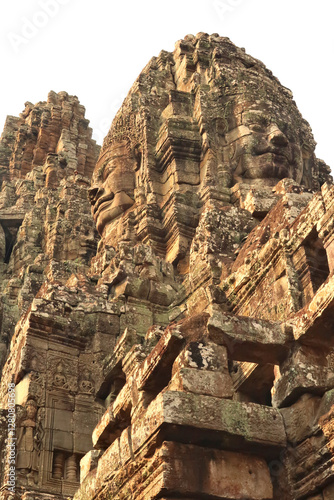 View from below up to the towers of the Bayon Temple, big faces are carved into the sandstone bricks, Angkor Wat, Siem Reap, Cambodia photo