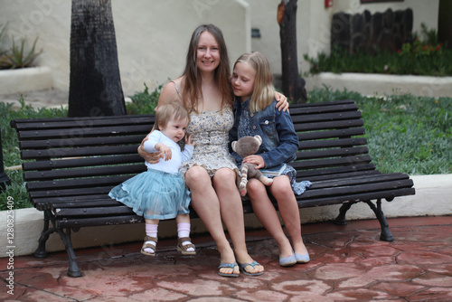 Happy Mother and two daughter. Woman, baby one year old and young child girl eight years old photo