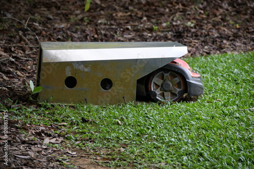 Robot mower inside its base to recharge the batteries before a new cycle of mowing grass.