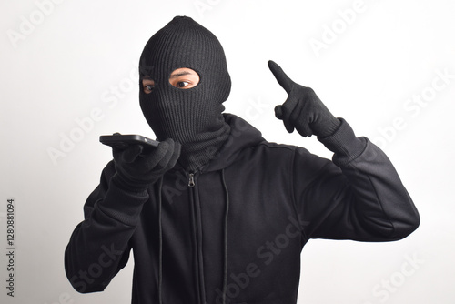 Foto Mysterious man wearing black hoodie and mask extorting money on smartphone call, isolated on white background
