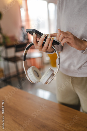 unknown woman connect mobile phone with headphones at home