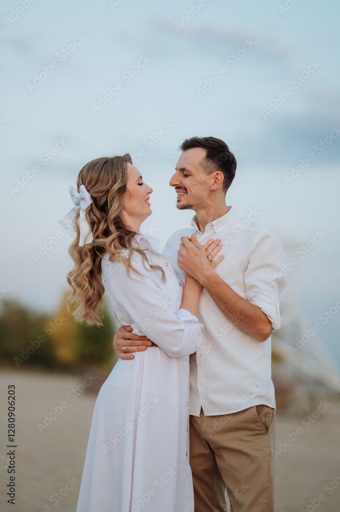 couple in love in white clothes hugging while standing on the sand, newlyweds, family relationships couple in love in white clothes hugging while standing on the sand, newlyweds, family relationships