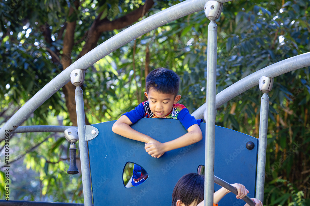 Fototapeta premium Asian kid boy climb in outdoor playground city park