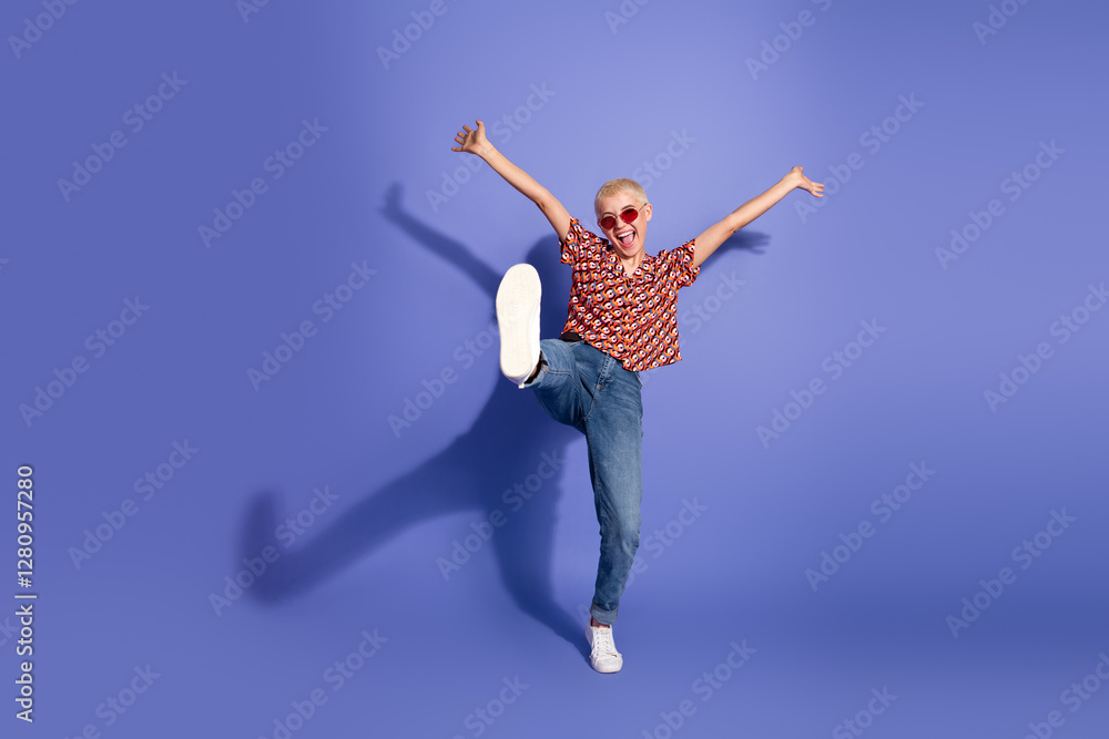 Fototapeta premium Cheerful young woman wearing casual clothing making joyful gestures on a vibrant purple background fashion.