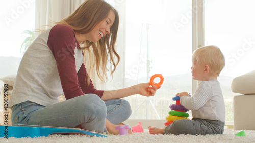 Konstfotografi Mother Sits With Baby Son At Home Playing With Plastic Stacking Toys