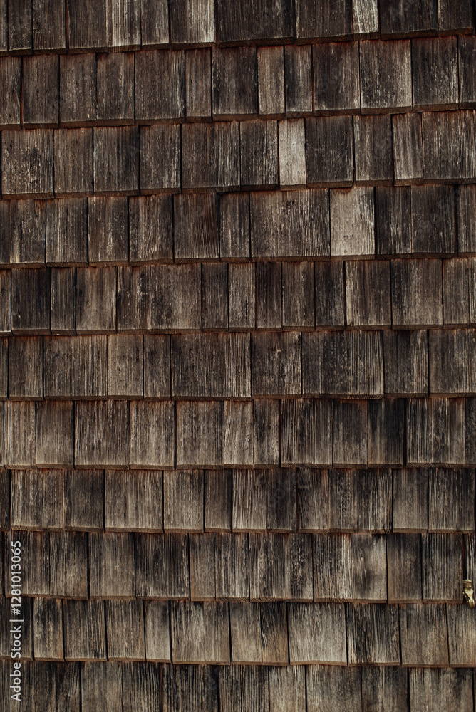 This image features a detailed texture of wooden shingles, showcasing their aged appearance and unique shapes. The interplay of light and shadow adds depth and character to the rustic surface. This image features a detailed texture of wooden shingles, showcasing their aged appearance and unique shapes. The interplay of light and shadow adds depth and character to the rustic surface.