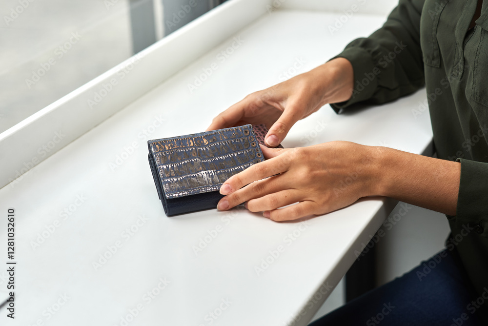 Crocodile leather wallet held in hands, sleek design, elegant accessory, at white table, stylish fashion concept