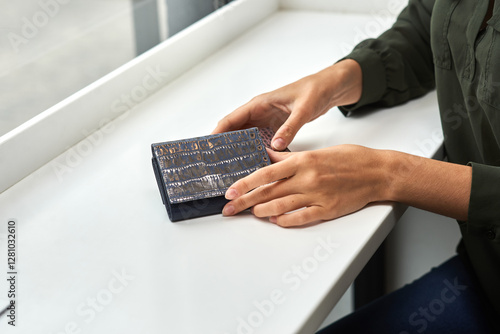 Obraz na płótnie Crocodile leather wallet held in hands, sleek design, elegant accessory, at white table, stylish fashion concept w salonie