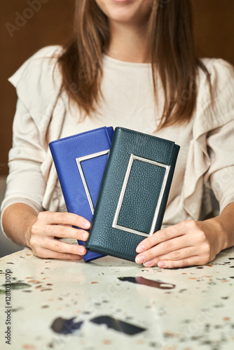 Woman holding elegant blue, green leather wallets minimalistic modern design stylish accessories concept