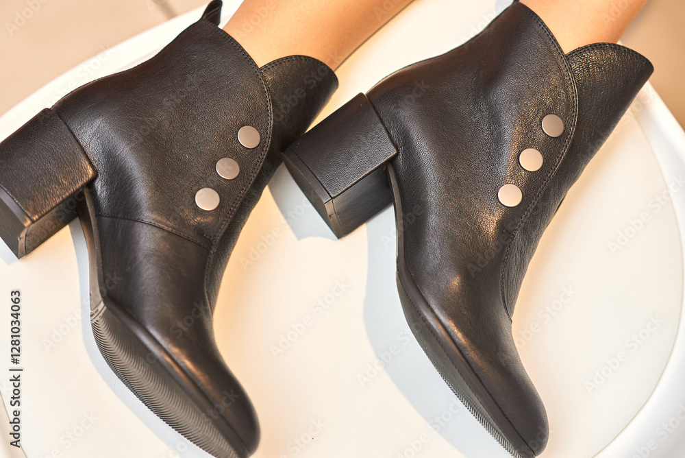 Fashionable, chic, stylish black leather ankle boots with decorative buttons, women's footwear elegance concept