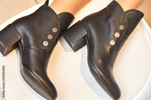 Obraz na płótnie Fashionable, chic, stylish black leather ankle boots with decorative buttons, women's footwear elegance concept w salonie