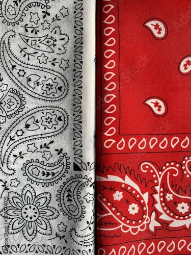 Two distinct bandana fabrics are shown side by side. One features a black and white paisley pattern, while the other showcases a bold red design with white motifs