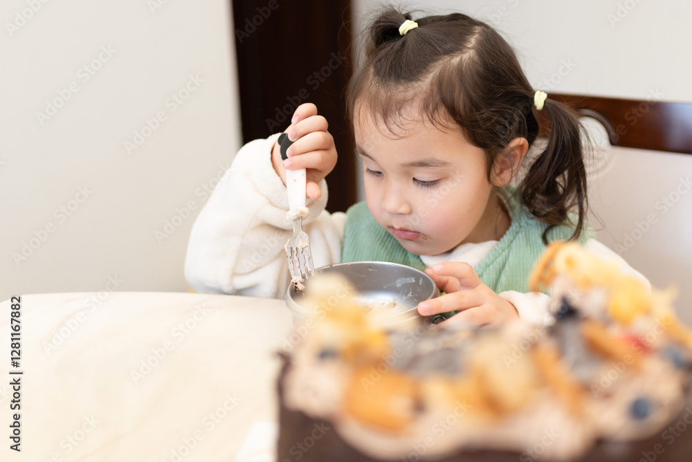 Beautiful multiracial girl eating homemade hot rice with duck meat and vegetables in a cup, sitting at the table in the kitchen. Beautiful multiracial girl eating homemade hot rice with duck meat and vegetables in a cup, sitting at the table in the kitchen.