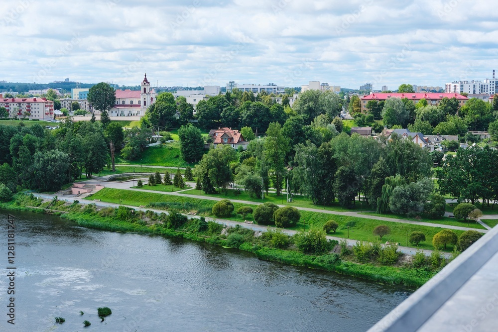 Obraz premium Cityscape, view from the observation deck above the river to the city blocks and green spaces along the river.
