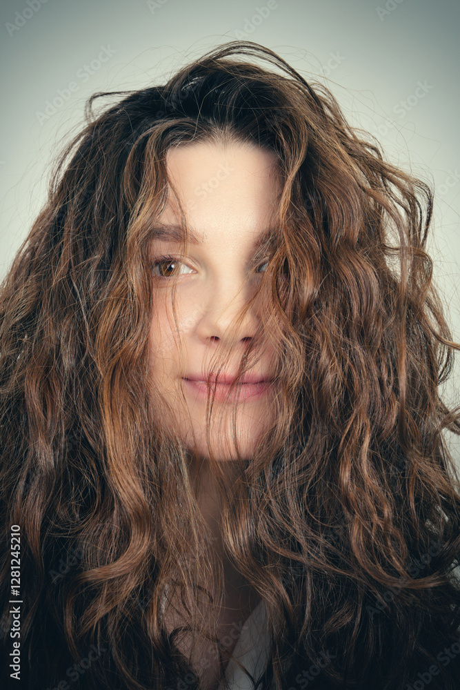 Beautiful girl with curly hairstyle. Tousled hairstyle. Studio photo. Selective focus. Toned image Beautiful girl with curly hairstyle. Tousled hairstyle. Studio photo. Selective focus. Toned image