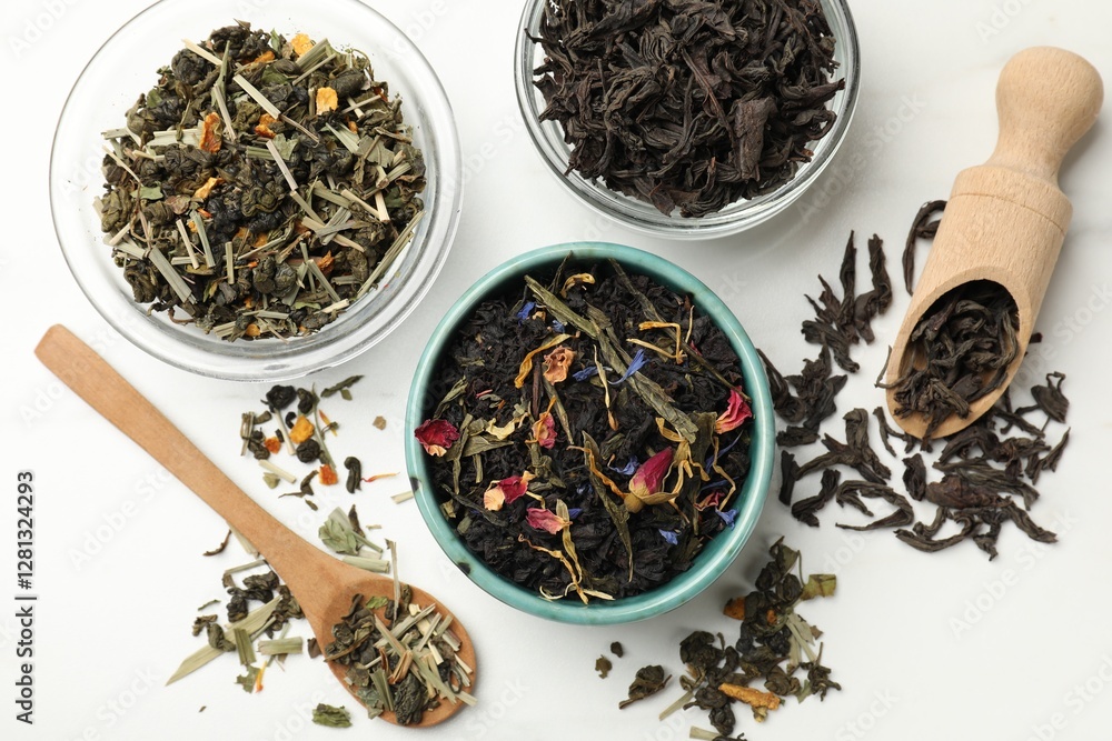 Fototapeta premium Different dry tea leaves on white table, flat lay