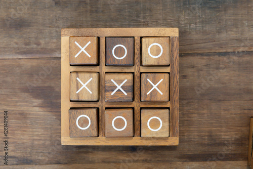 A wooden board with the letters X and O on it. tic tac toe wooden game on timber table.
