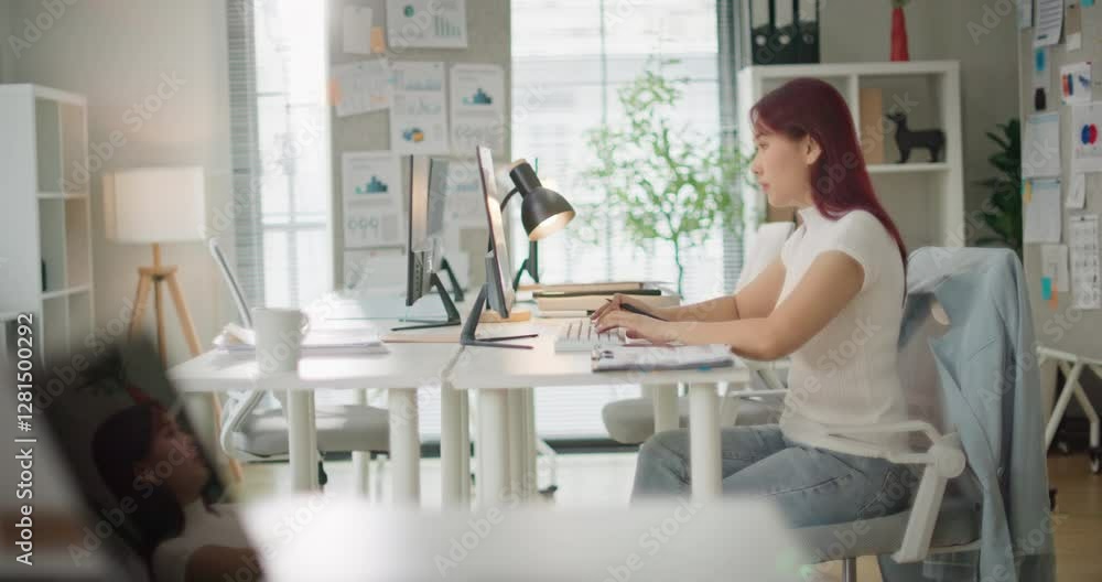 Concentrated asian business woman working on laptop computer in office. Focused female freelancer entrepreneur making data analysis on project paperwork planning success strategy Candid shot side view Concentrated asian business woman working on laptop computer in office. Focused female freelancer entrepreneur making data analysis on project paperwork planning success strategy Candid shot side view