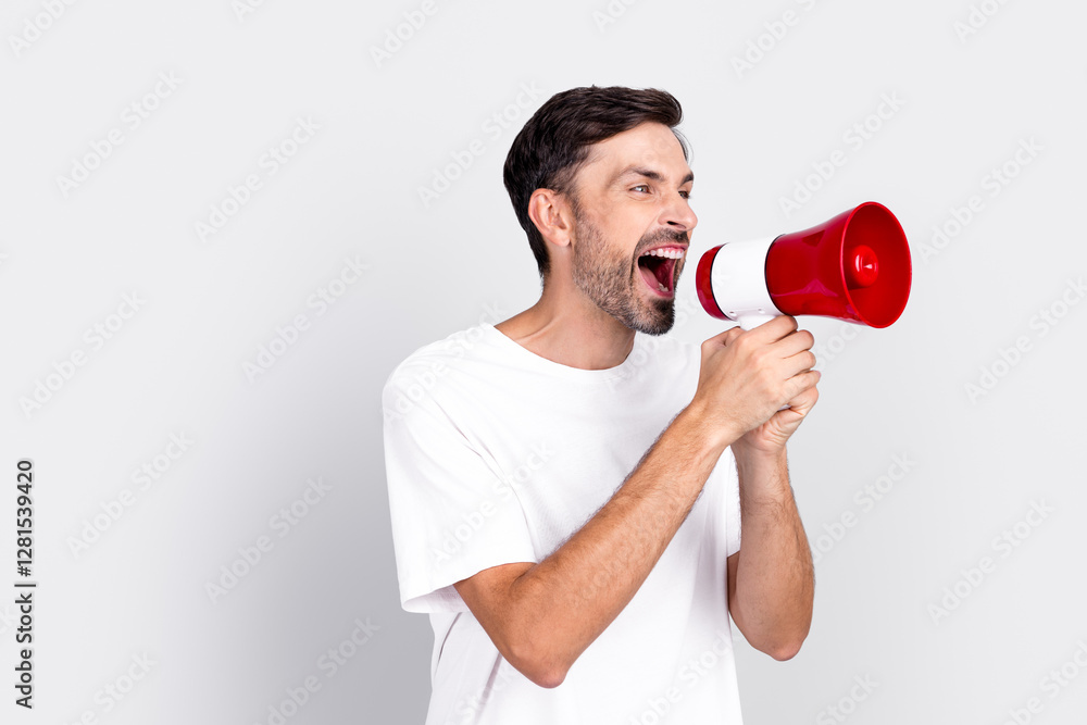 Young Stylish Man Shouting with a Megaphone in a White T-Shirt Against a Grey Background Young Stylish Man Shouting with a Megaphone in a White T-Shirt Against a Grey Background