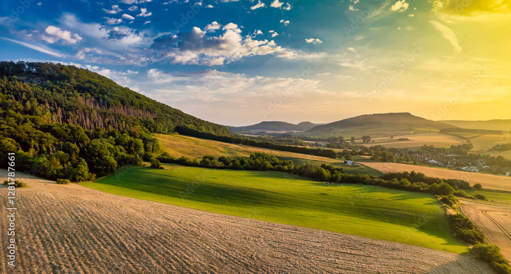 Golden Sun Casts a Warm Glow Over Rolling Hills and Lush Fields in the Countryside at Sunset