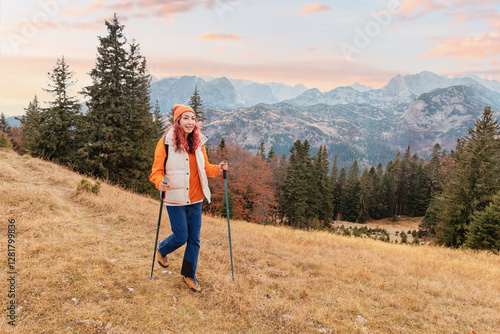 Obraz na płótnie Female hiker using trekking poles walking on mountain trail enjoying Durmitor massif landscape at sunset w salonie