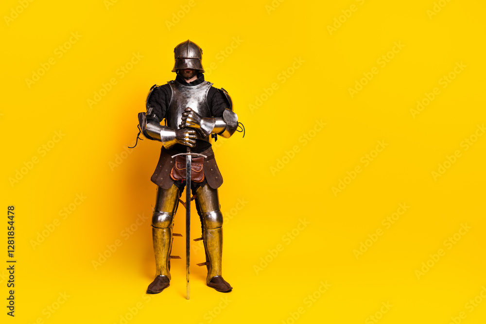 Medieval knight in full armor posing on bright yellow background with noble stance Medieval knight in full armor posing on bright yellow background with noble stance