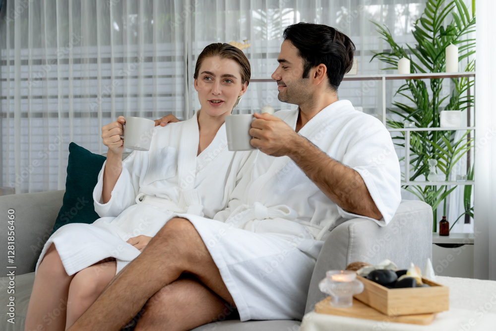 Beauty or body treatment spa salon vacation lifestyle concept with couple wearing bathrobe relaxing with drinks in luxurious hotel spa or resort room. Vacation and leisure relaxation. Quiescent Beauty or body treatment spa salon vacation lifestyle concept with couple wearing bathrobe relaxing with drinks in luxurious hotel spa or resort room. Vacation and leisure relaxation. Quiescent