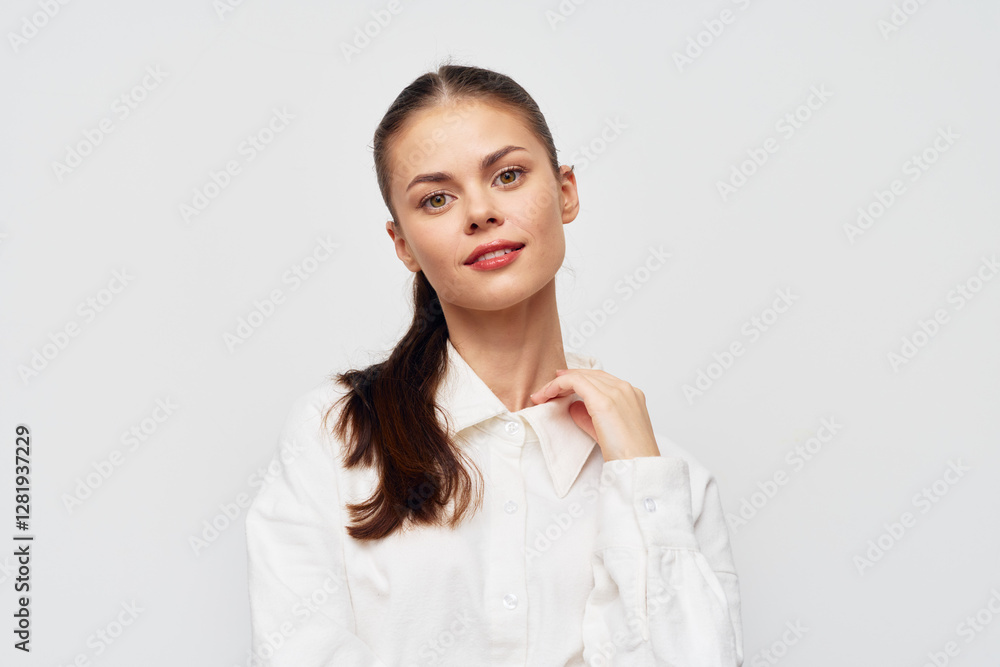 Young woman in a white shirt against a plain background, showcasing a confident expression and stylish appearance, perfect for fashion or portrait themed projects Young woman in a white shirt against a plain background, showcasing a confident expression and stylish appearance, perfect for fashion or portrait themed projects